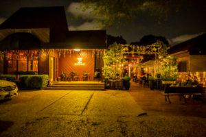 A lively bar scene in Rice Village, Houston, featuring a cozy and vibrant atmosphere with patrons enjoying cocktails and craft beers at Simone on Sunset.