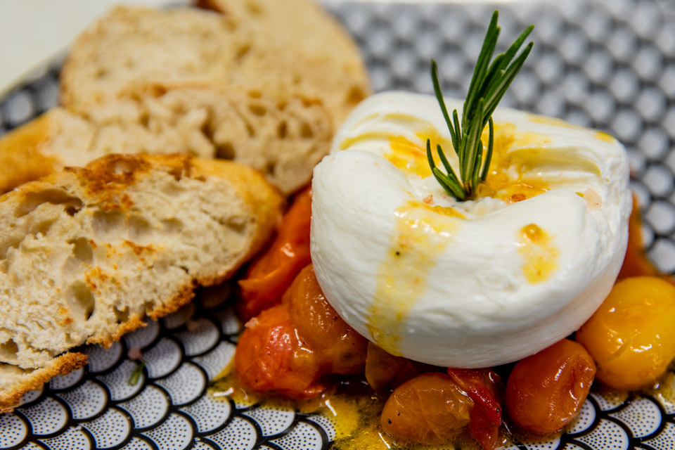 Burrata with sweet roasted cherry tomatoes and rosemary at Simone on Sunset in Rice Village, Houston.