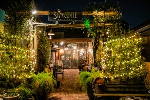 Entrance of a classy cocktail bar in Houston at Simone on Sunset with warm string lights