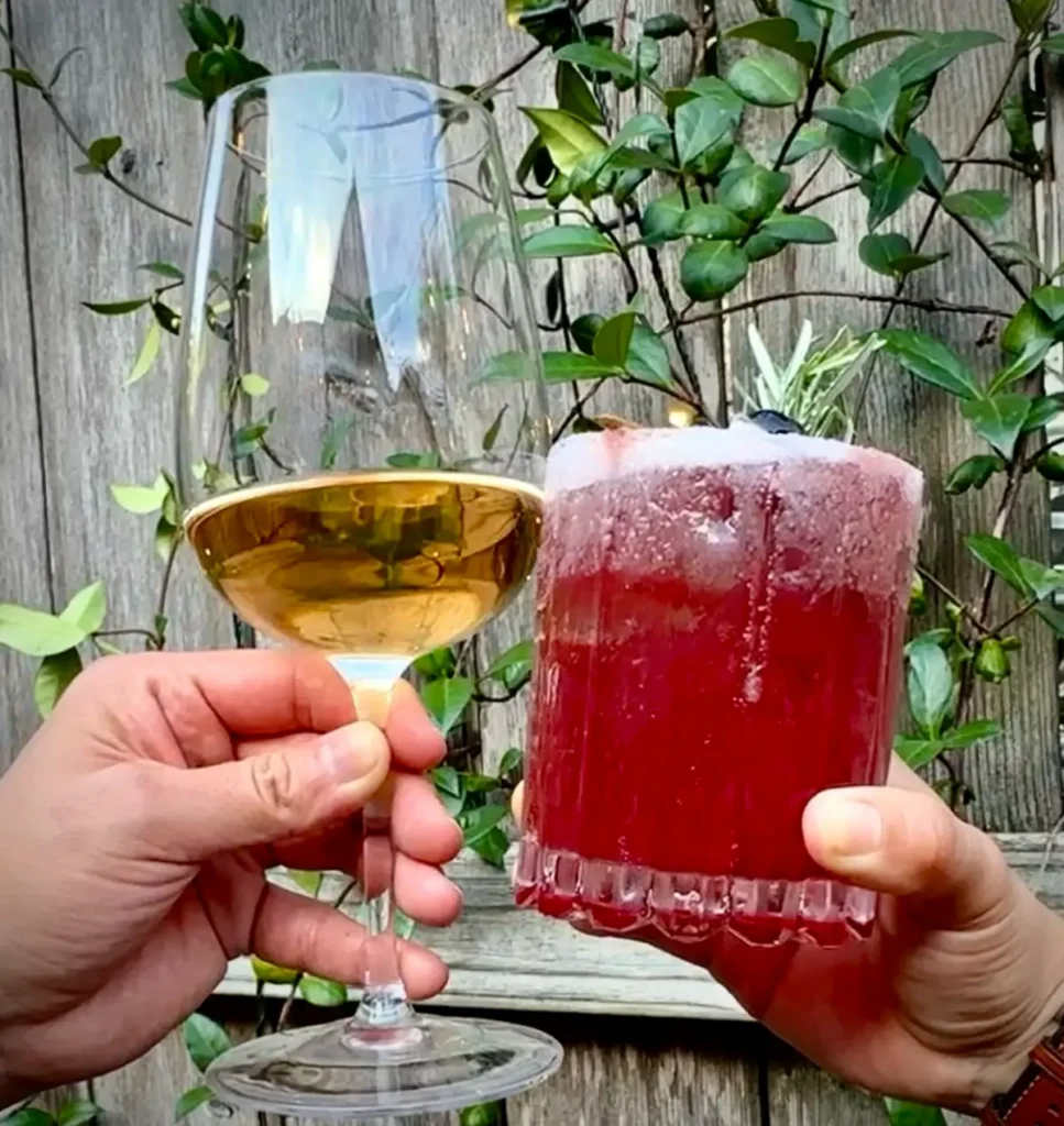 Romantic wine bar in Houston near you featuring a white wine and red cocktail toast in a cozy patio setting