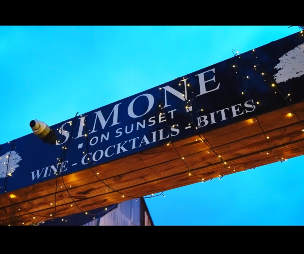 Simone on Sunset sign at wine and cocktail bar during a late night Houston evening
